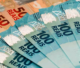 Amontoado de notas de 100 e 50 reais, simbolizando a mudança na tributação do Brasil